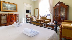 Een hotelkamer met een groot bed, een houten kast, een televisie en een balkon met uitzicht.