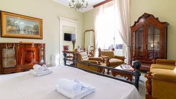 Une chambre d’hôtel avec un grand lit, une armoire en bois, une télévision et un balcon avec vue.