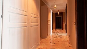 A hallway with white doors, a patterned floor, and pendant lighting. - Cocco e Dessì Home- Mattia (ORISTANO)