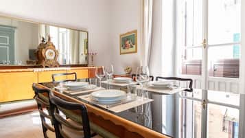 A dining area with a long table, chairs, and a large mirror.