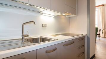A modern kitchen with stainless steel appliances, a double sink, and light-colored cabinetry.