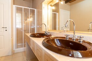 A bathroom with two sinks, a glass shower enclosure, and a large mirror. - Residenza Deriu- Vanna (Bosa)