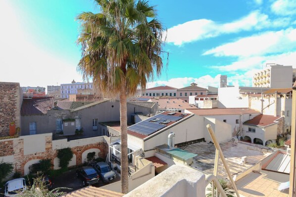 Zona residencial com palmeira, carros estacionados e edifícios com painéis solares.