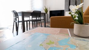 Zona pranzo con tavolo, sedie, una mappa e un'orchidea in vaso.