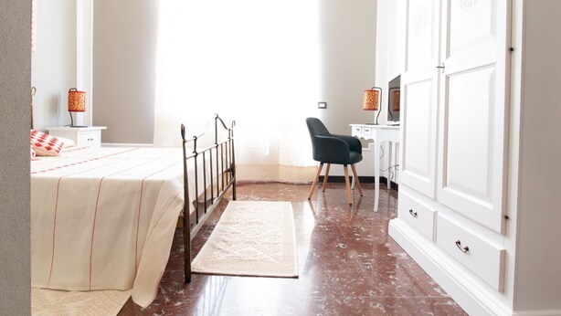 A bedroom with a bed, desk, chair, wardrobe, and a window. - Cocco e Dessì Home- Tamara (ORISTANO)
