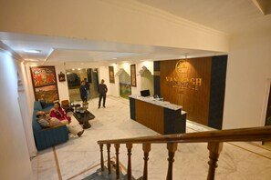 A hotel lobby with a reception desk, seating area, and artwork on the walls. - The Van Bagh Ranthambore (Sawai Madhopur)