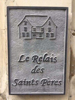 A metal plaque with a house illustration and the text "Le Relais des Saints Pères". - Maison d'hôtes - Le Relais des Saints Pères  (Auxerre)