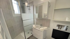 A modern bathroom with a shower, sink, and toilet. - Le Chaleureux - Charmant T2 proche metro (Toulouse)