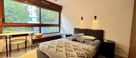 Escritorio, tabla de planchar con plancha, wifi y ropa de cama