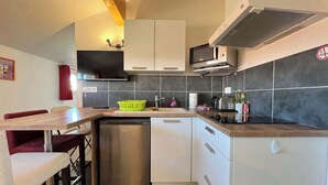 Een moderne keuken met witte kasten, een roestvrijstalen vaatwasser en een magnetron.