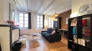 Ein großzügiger Wohnbereich mit einer schwarzen Couch, einem Couchtisch und einem Bücherregal.