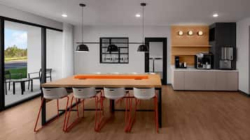 A modern kitchen with a wooden countertop, black pendant lights, and a coffee machine.