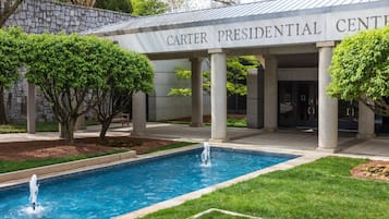 The exterior of the Carter Presidential Center with a pool and trees.