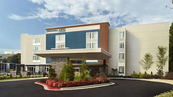A modern hotel with a flat roof, a stone base, and a sign reading "SPRINGHILL SUITES."