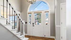 A staircase leading to a door with a view of trees and a clear sky. - 5BR Group Retreat | Hot Tub, Deck & Workspace (Saint Charles)