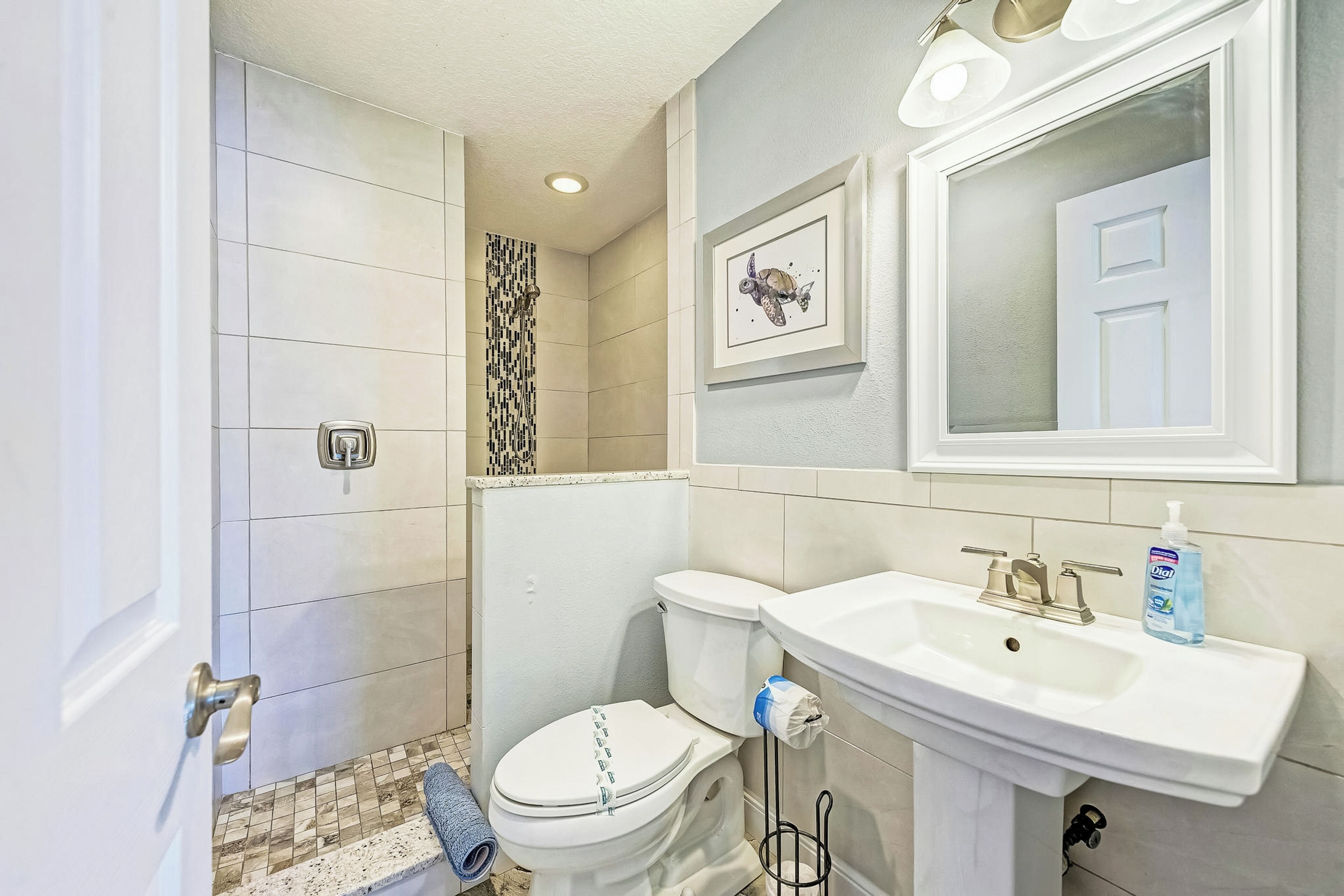 A bathroom with a toilet, sink, and shower.