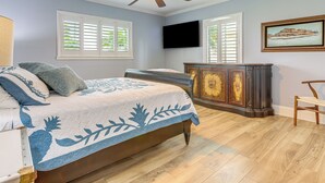 A bedroom with a bed, a ceiling fan, a dresser, and a TV mounted on the wall. - Jensen Beach Indian River Waterfront Retreat (Jensen Beach)