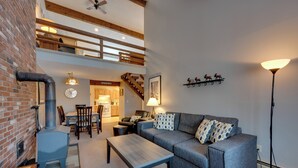 A spacious living area with a fireplace, a sofa, a coffee table, and a dining area. - 3 Mi to Story Land: All-season Family Condo (Bartlett)