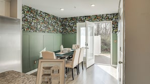 A dining area with a green wall, a framed picture of a house, and a table with chairs. - Quiet & Comfy Spring Hill Townhome w/ WFH Setup (Spring Hill)