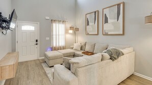 A living room with a sectional sofa, a wooden coffee table, and a TV mounted on the wall. - Quiet & Comfy Spring Hill Townhome w/ WFH Setup (Spring Hill)