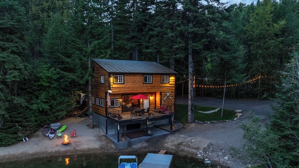 A cabin with a deck, dock, kayaks, and a fire pit. - Hot Tub & Fire Pit: Getaway on Pend Oreille River (Priest River)