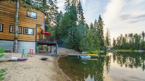 A wooden cabin with a deck, a dock, and boats. - Hot Tub & Fire Pit: Getaway on Pend Oreille River (Priest River)