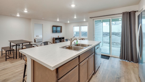 A modern kitchen with a large island, built-in appliances, and a sliding glass door leading to a balcony. - Walk to The Plains Golf Course: Getaway in Cheney! (Cheney)