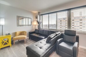 A modern living room with a sectional sofa, a yellow side table, and a black armchair. - 6 Mi to Downtown Cleveland: Lakeview Condo! (Lakewood)