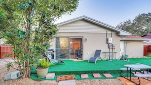 A house with a patio, a lawn, and a small garden area with a tree and a potted plant. - Pet-friendly Horse Capital Hub w/ Patio & Yard (Ocala)