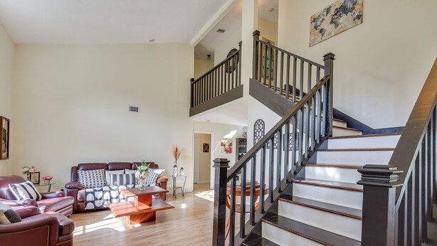 A spacious living room with a staircase leading to an upper floor. - Outdoor Kitchen & Gaming Garage: Bradenton Retreat (Bradenton)