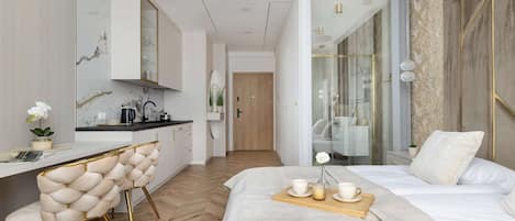 Una habitación de hotel moderna con una cama, una barra de desayuno y vistas a la ciudad.