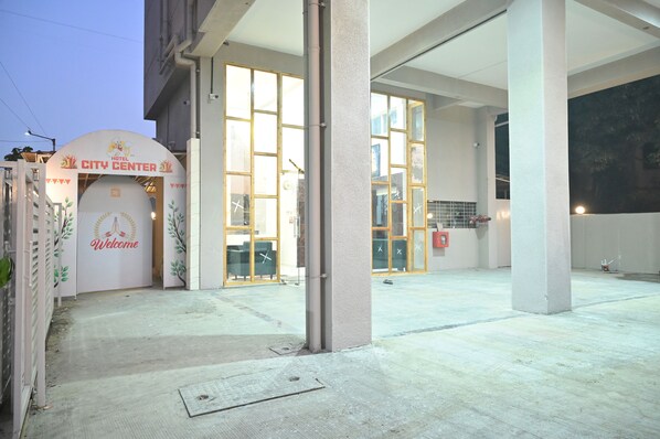 Exterior de un hotel con un cartel de 'Welcome', amplias ventanas de vidrio y un letrero de 'City Center'.