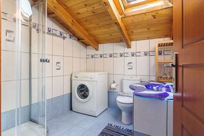 Een haardroger, handdoeken, zeep, toiletpapier