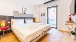 A modern hotel room with a bed, bedside table, and a view of the outside. - GuestHost - Spacious room with balcony that can accommodate up to 4 people, located in a convenient and central position, in a building with concierge. The accommodation is located just 10 minutes walk from the historic center, in an area equipped with e (Bari)
