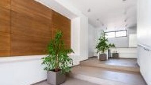 A modern interior with a staircase, potted plants, and a wooden accent wall. - GuestHost - Spacious room with balcony that can accommodate up to 4 people, located in a convenient and central position, in a building with concierge. The accommodation is located just 10 minutes walk from the historic center, in an area equipped with e (Bari)