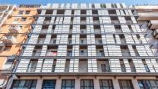 A multi-story building with a grid of windows, balconies, and a flat roof. - GuestHost - Spacious room with balcony that can accommodate up to 4 people, located in a convenient and central position, in a building with concierge. The accommodation is located just 10 minutes walk from the historic center, in an area equipped with e (Bari)