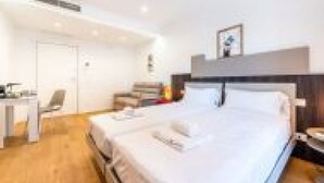 A hotel room with a bed, a desk, and a chair. - GuestHost - Spacious room with balcony that can accommodate up to 4 people, located in a convenient and central position, in a building with concierge. The accommodation is located just 10 minutes walk from the historic center, in an area equipped with e (Bari)