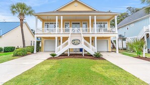 A two-story house with a balcony, a front porch, and a garage. - Private House w/Private Pool, 0.3 miles from beach + Free Attraction Tickets! (North Myrtle Beach)