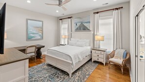 A bedroom with a bed, bedside tables, a chair, a desk, and a ceiling fan. - Private House w/Private Pool, 0.3 miles from beach + Free Attraction Tickets! (North Myrtle Beach)