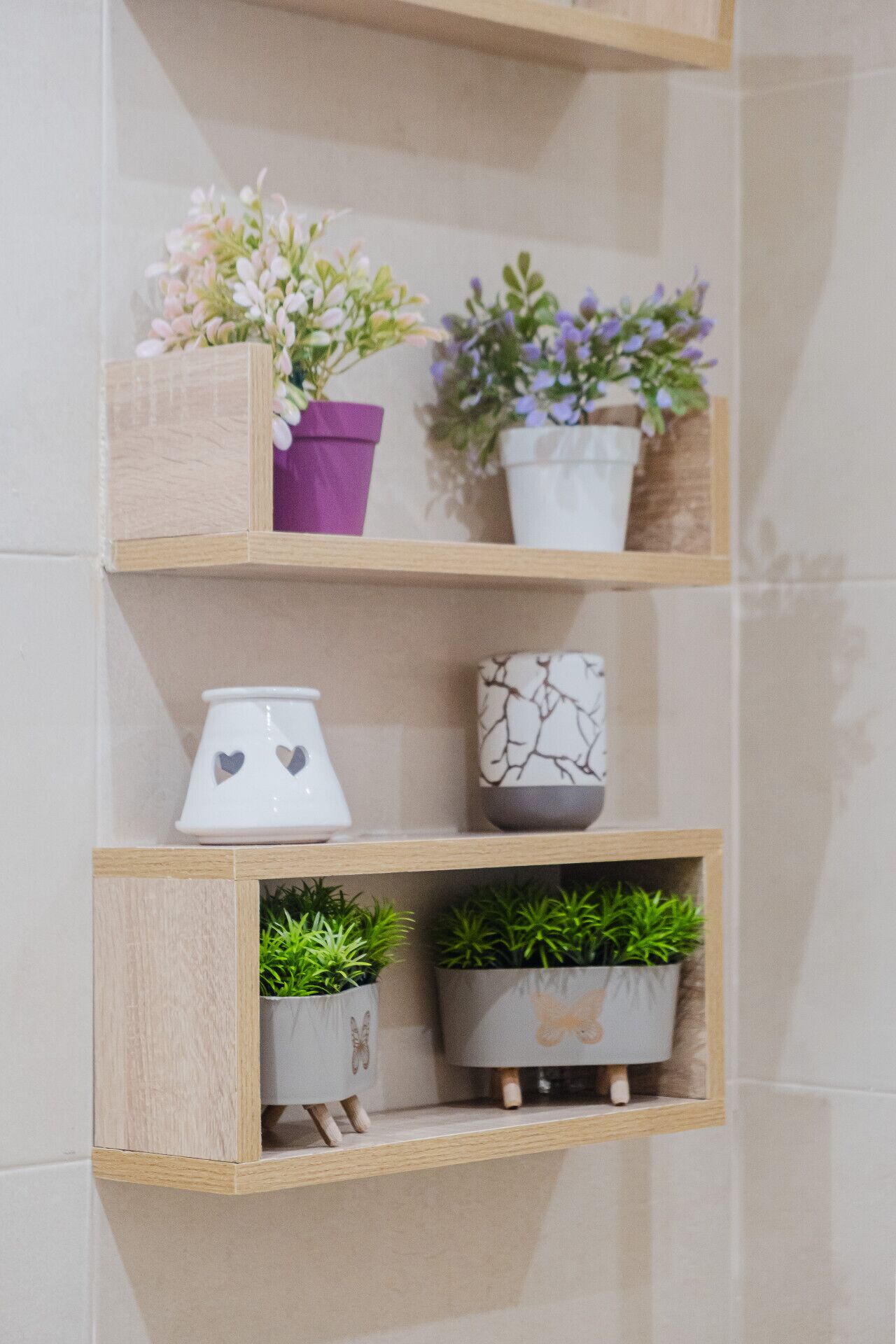 Un baño con estantes de madera que exhiben macetas y objetos decorativos.