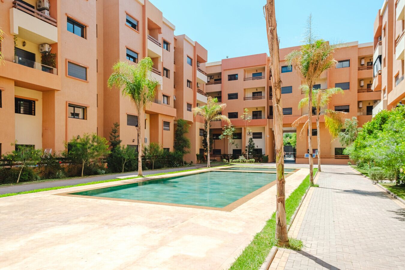 A courtyard with a swimming pool surrounded by apartment buildings.