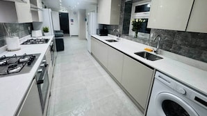 Uma cozinha moderna com ilha central, eletrodomésticos embutidos e máquina de lavar louça.