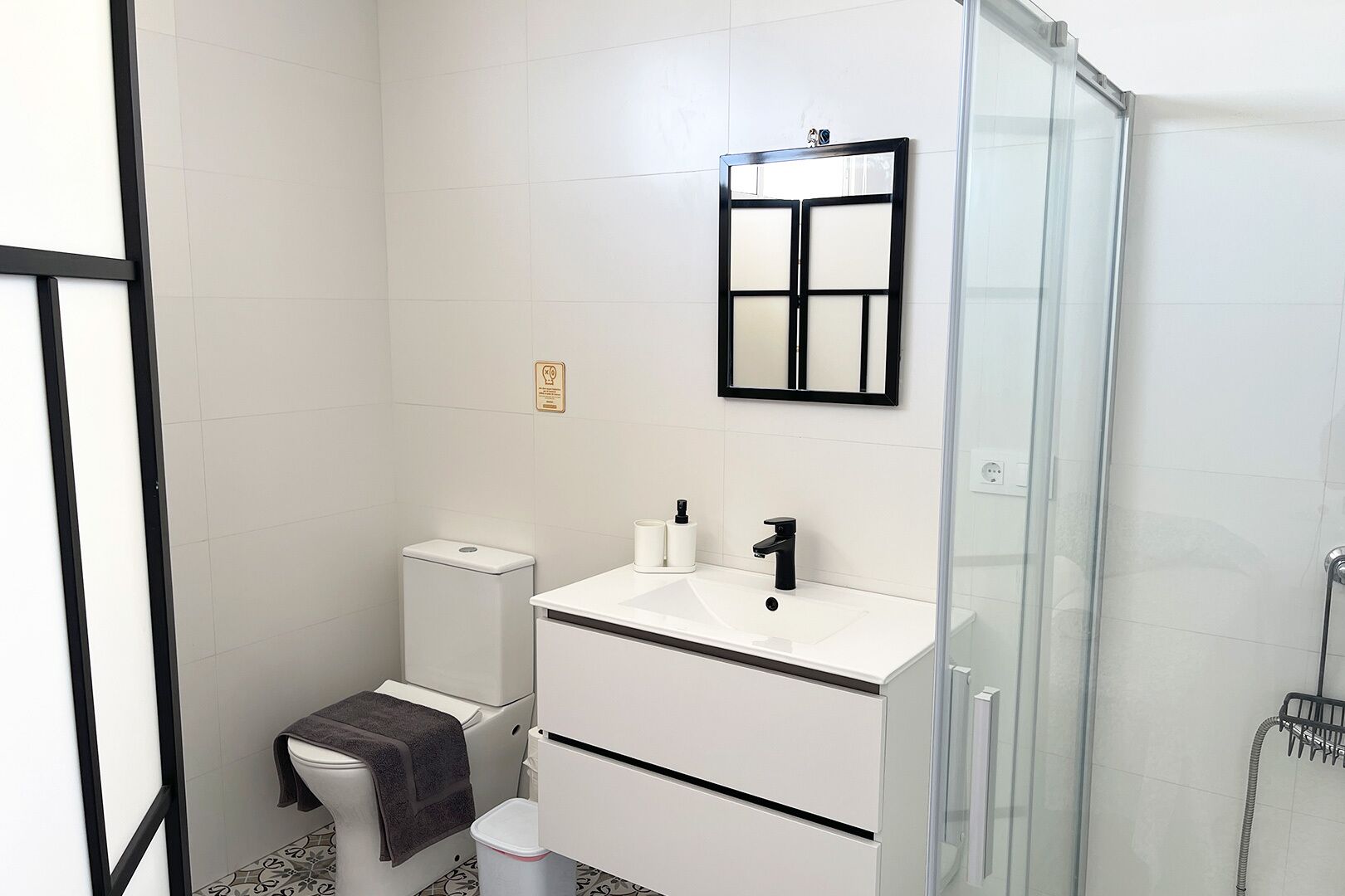 Un baño moderno con inodoro, lavamanos y ducha.
