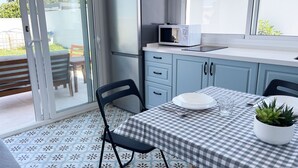 A modern kitchen with a checkered tablecloth, a microwave, and a potted plant. - Agoodplan Playa El Palmar de Vejer (Vejer de la Frontera)