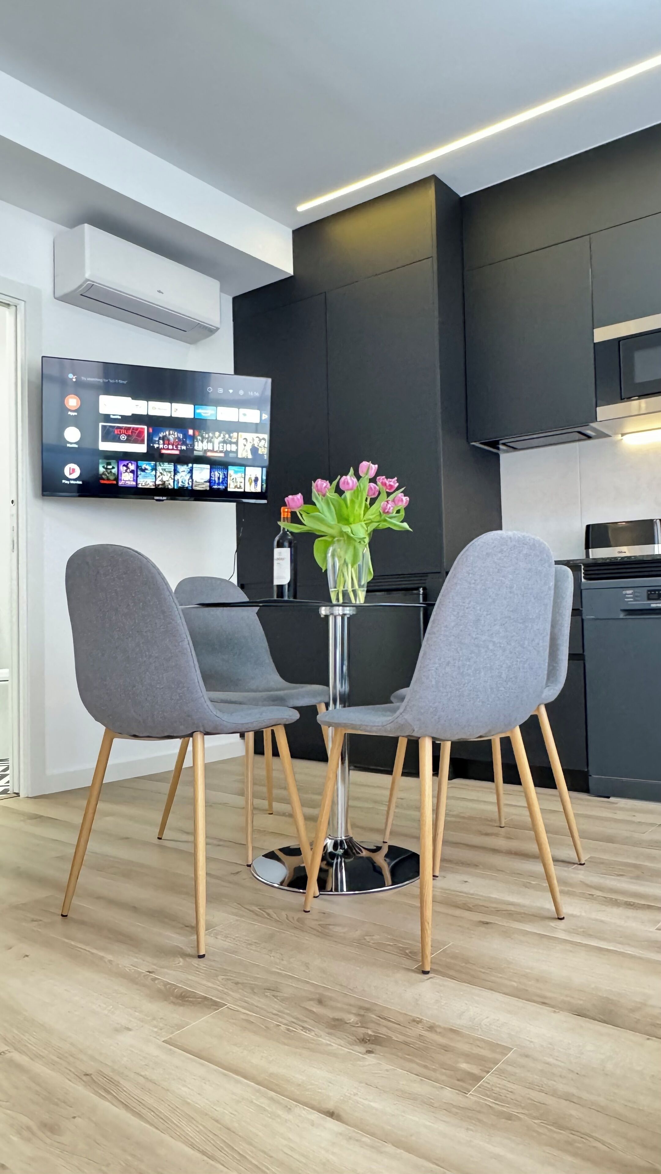 Une cuisine moderne avec un téléviseur à écran plat fixé au mur, qui affiche différentes applications.