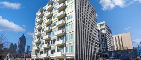 Un edificio de varios pisos con un diseño arquitectónico moderno, con balcones en cada planta.