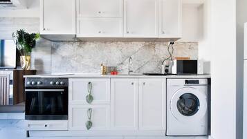 Horno, parrilla de estufa, cafetera y tetera y utensilios de cocina