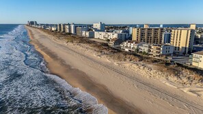 Eine Küstenwohngegend mit Häusern direkt am Strand, einem Sandstrand und freiem Blick auf den Ozean.