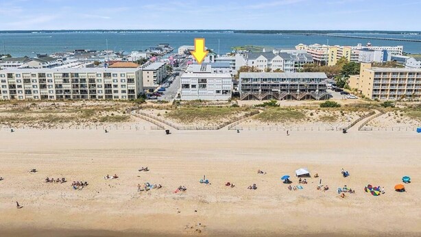 Een hotel aan het strand met meerdere gebouwen, een zandstrand en uitzicht op de oceaan.