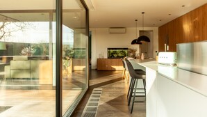 Una cocina moderna con una isla grande, horno empotrado y refrigerador de acero inoxidable.
